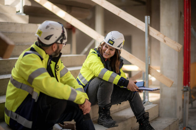 Anställda på JSB pratar sittandes i en trappa