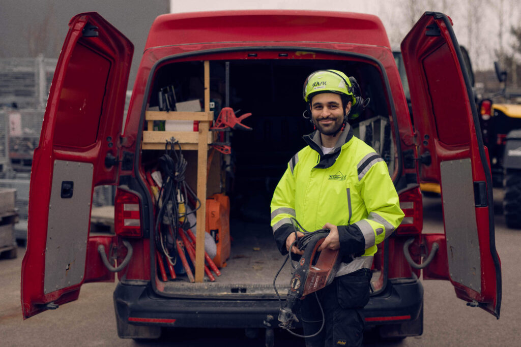 En byggarbetare står vid sin servicebil, fullt uppkopplad med Infobric Fleets system