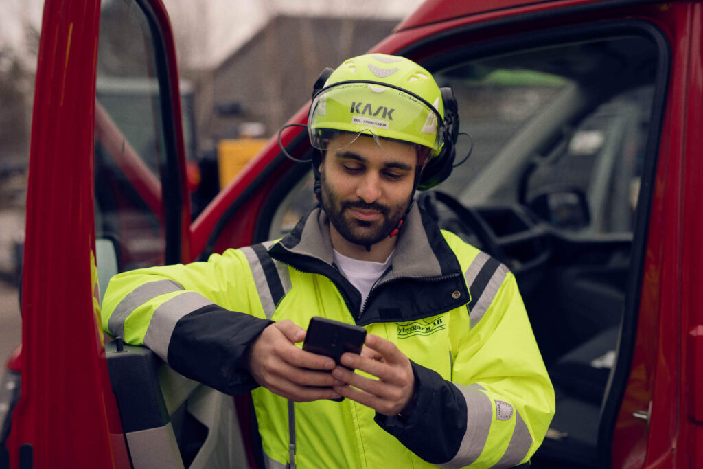 Arbetande person är uppkopplad via mobilen och sitt Infobric Fleet Management system