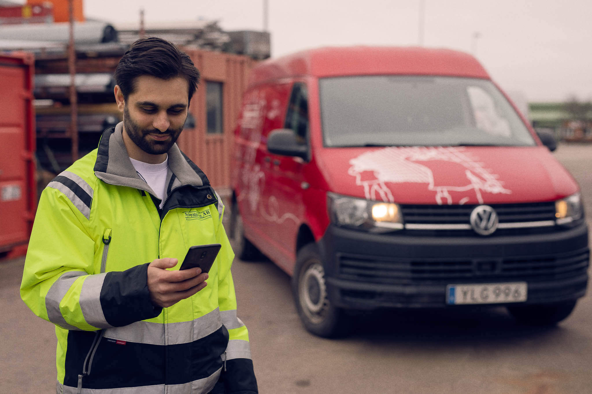 Albert tittar på milersättningen på sin mobil framför sin bil