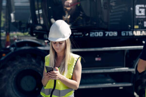 kvinna på byggarbetsplats med app